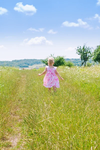 Liten flicka kör i fältet — Stockfoto