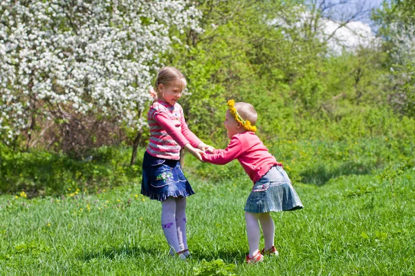 Little girls playing on a spring meadow — Stock Photo, Image