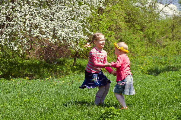 Niñas jugando en un prado de primavera —  Fotos de Stock