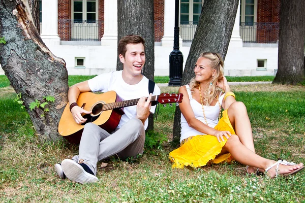 Uomo e donna con una chitarra nel parco — Foto Stock