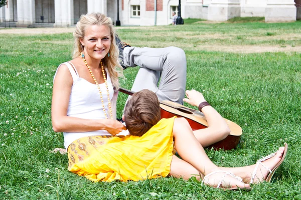 Homem e mulher com uma guitarra no parque — Fotografia de Stock