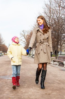 Anne ve kızı parkta yürüyor.