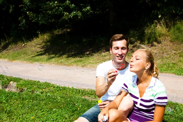 Man and woman blow bubbles — Stock Photo, Image