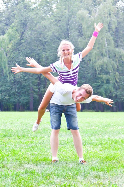 Man bedrijf vrouw op zijn rug — Stockfoto