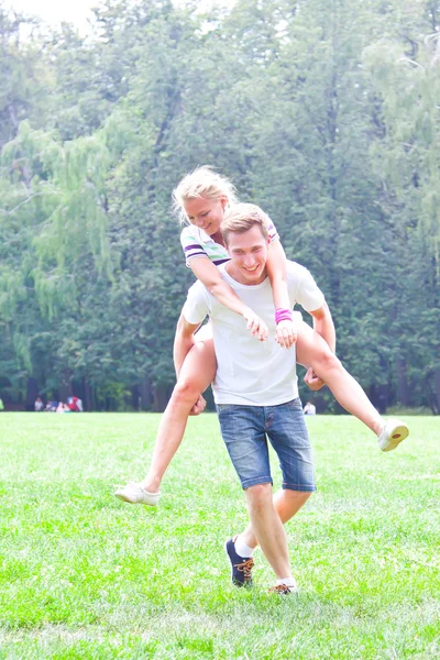 Man bedrijf vrouw op zijn rug — Stockfoto