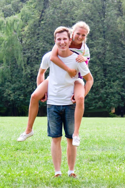 Man holding woman on his back — Stock Photo, Image