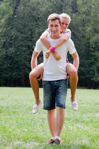 Man holding woman on his back — Stock Photo, Image