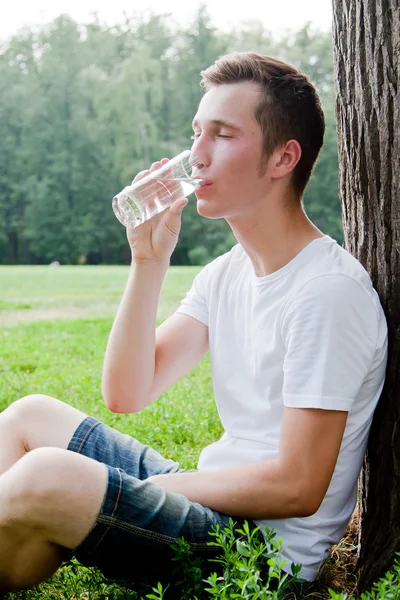 El hombre bebe agua en el parque — Foto de Stock