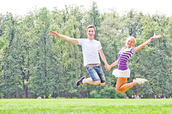 Man and woman jumping in the park — Stock Photo, Image