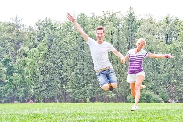 Homme et femme sautant dans le parc — Photo