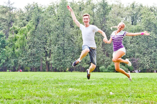 Homme et femme sautant dans le parc — Photo