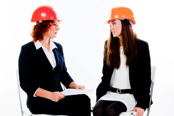 Två kvinnor i konstruktion hjälmar — Stockfoto
