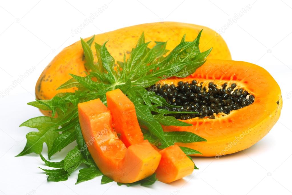 Ripe papaya with seeds and green leaf isolated on a white backgr