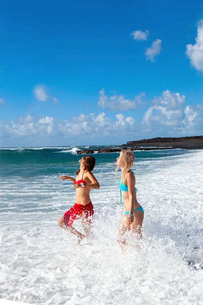 Glada tjejer på stranden med svart sand — Stockfoto