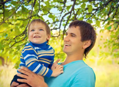 doğada oldukça küçük bir çocuk tutan genç Baba