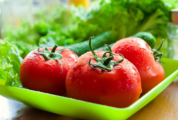Несколько спелых помидоров и огурцов на столе — стоковое фото