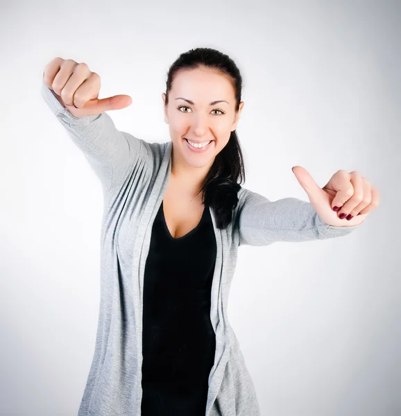 Portrait of a young girl smiling brunette with a thumbs up — Stock Photo, Image