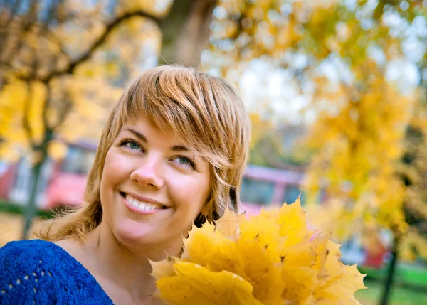 Jonge meisje in glimlachend vallen esdoorn bladeren — Stockfoto