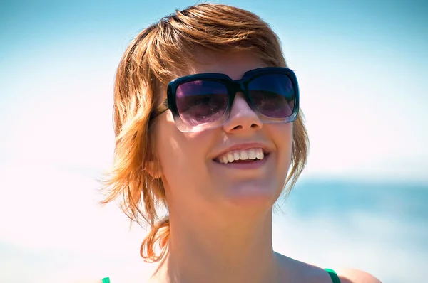 Smiling face of a young woman wearing glasses outdoors — Stock Photo, Image