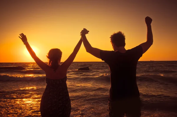 Jovem casal perto da costa ao pôr do sol — Fotografia de Stock
