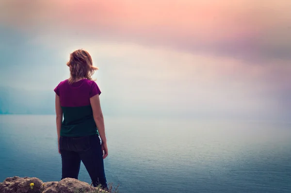 Młoda dziewczyna stoi na klifie nad morzem Zdjęcia Stockowe bez tantiem