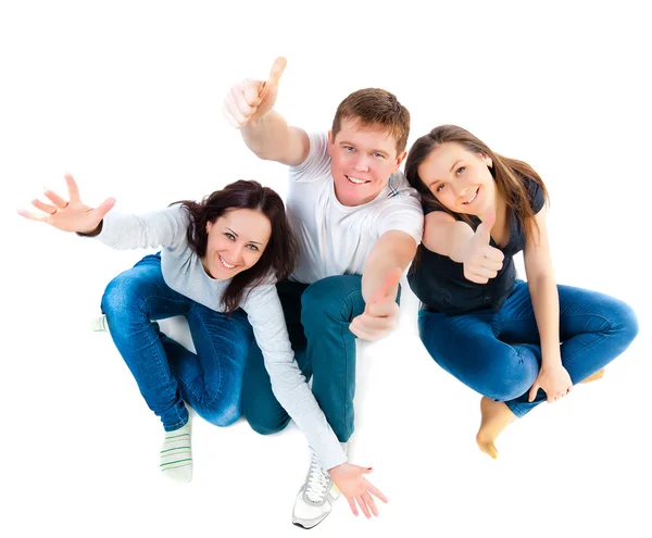 Top view of young friends sitting on the floor and showing thumb — Stock Photo, Image