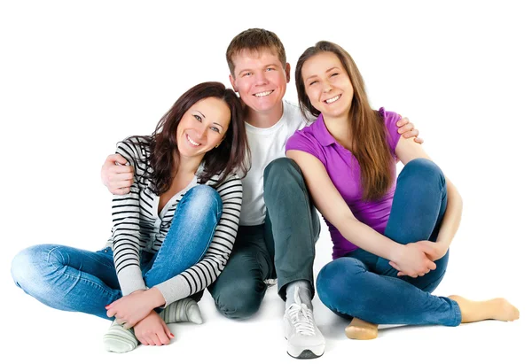 Happy young friends sitting on the floor — Stock Photo, Image
