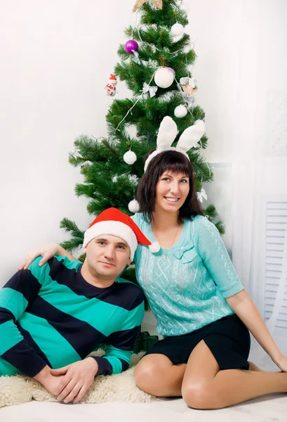 Jeune couple sous le sapin de Noël — Photo