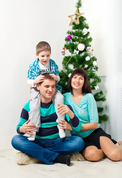 Jonge gezin plezier onder de kerstboom — Stockfoto