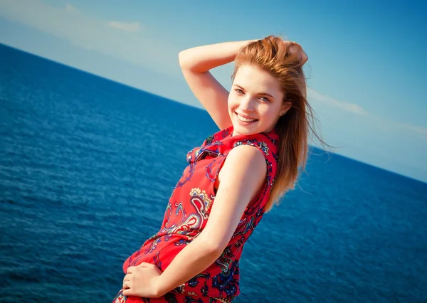 Portrait of young happy woman posing on sea background — Stock Photo, Image