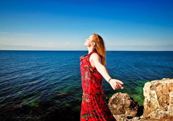 Krásná mladá dívka si užívá moře na jasný slunečný den — Stock fotografie