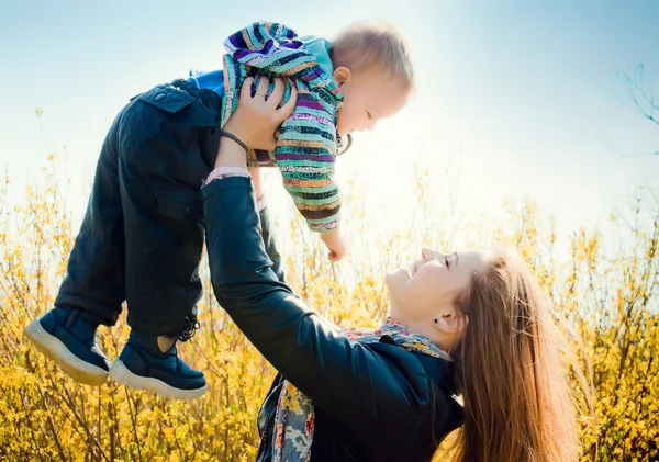 Jonge moeder wandelingen in het park met zijn jonge zoon — Stockfoto