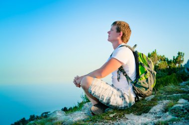 Genç turizm ile tepede oturan sırt çantası ve sc keyfini çıkarın