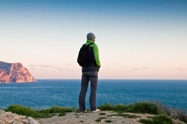 Giovane si erge su una collina al tramonto — Foto Stock