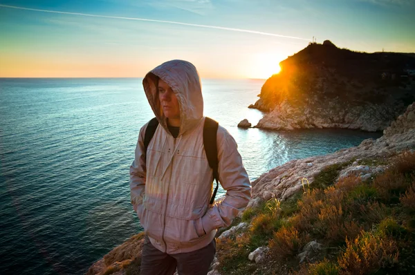 Giovane viaggiatore solitario su una collina al tramonto — Foto Stock