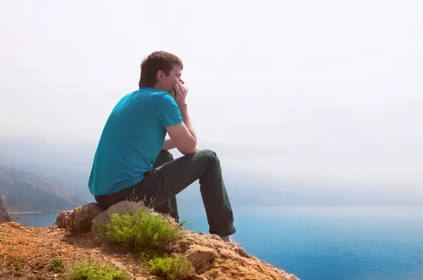 Samotny facet patrząc do odległości na morzu — Zdjęcie stockowe