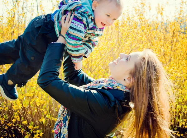 Giovane madre cammina nel parco con il suo giovane figlio — Foto Stock