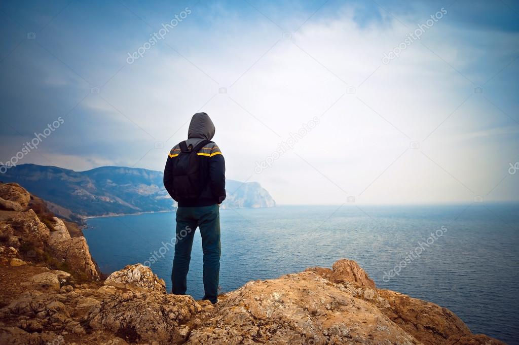 Young guy looking into the distance at sea