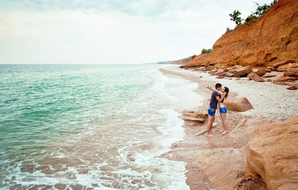 Young couple hugging near the sea shore... — Stock Photo, Image