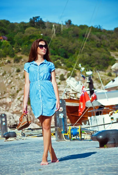 Menina caminha no cais no mar em um fundo de iates — Fotografia de Stock