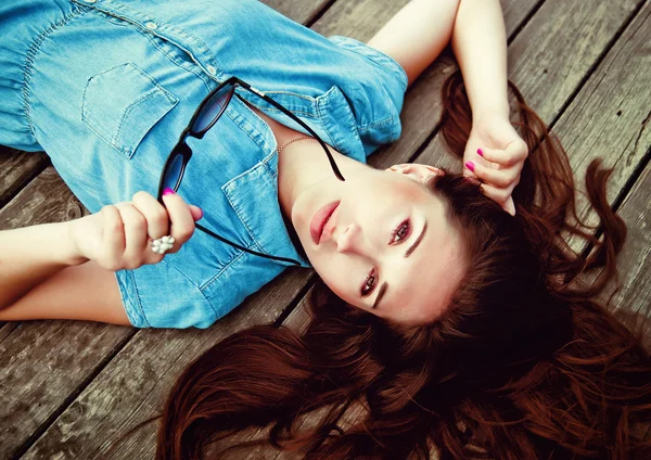 Beautiful girl lying on a wooden floor — Stock Photo, Image