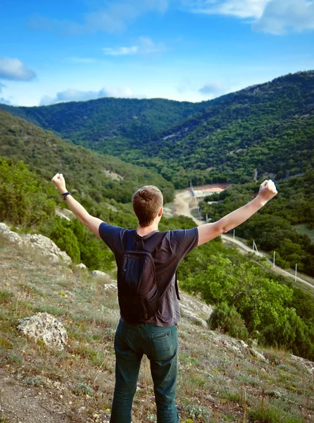 Giovane turista in montagna con le braccia alzate — Foto Stock