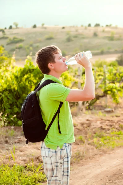 Junge Touristen trinken Wasser in der Natur — Stockfoto