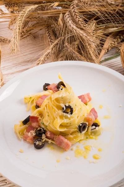 Tagliatelle con pancetta e annerire a quelle di oliva — Foto Stock