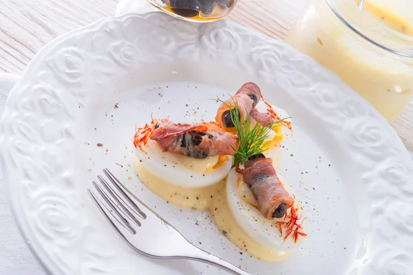 Eggs with ham and black olive ones — Stock Photo, Image