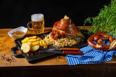 Lahana turşulu domuz budu, tatlı hardal ve kızarmış patates.