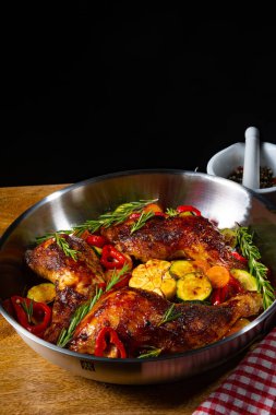 Çeşitli sebze ve baharatlarla kızarmış tavuk bacağı.