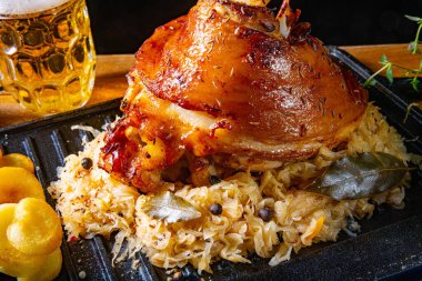 Lahana turşulu domuz budu, tatlı hardal ve kızarmış patates.