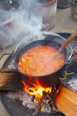 Mutfakta ateş ve sebzeli tencere var.