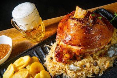 Lahana turşulu domuz budu, tatlı hardal ve kızarmış patates.